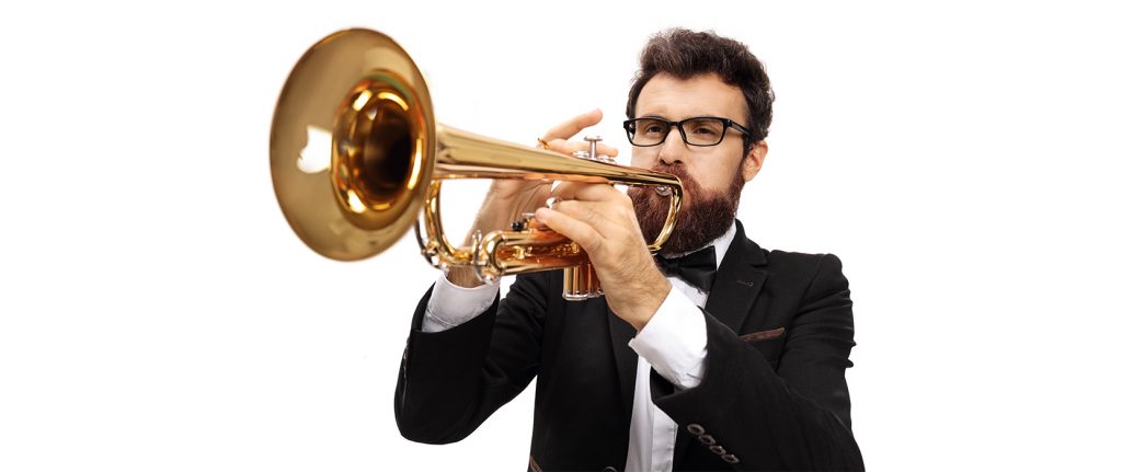 A man plays a trumpet against a white background, there are white notes hanging in the air above him. The man is dark haired, Caucasian, and wears a black suit with a white shirt. For blog: Question?